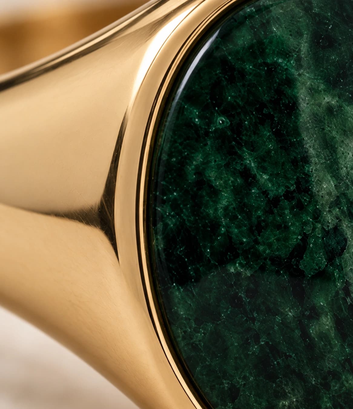 Close-up of the green gemstone and gold setting