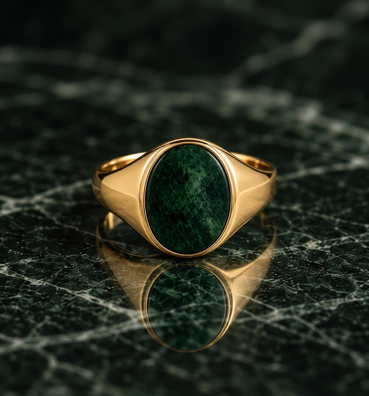 Green gemstone ring reflected on a dark green surface